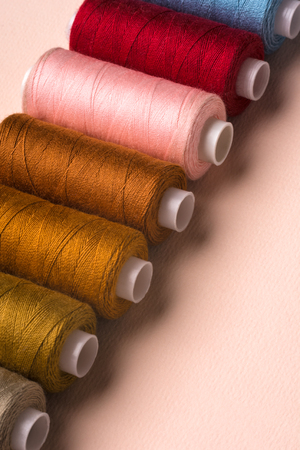 Coils with multi-colored threads on a pink background.