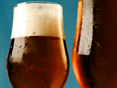 Two mugs of beer on a blue background.