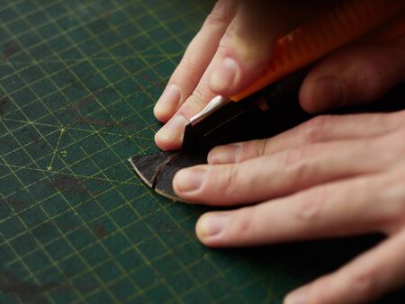 Shaping the tip of the leather strap with a knife.