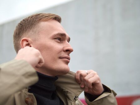 Autumn mood, young guy in a raincoat trench coat underground, street style.の写真素材