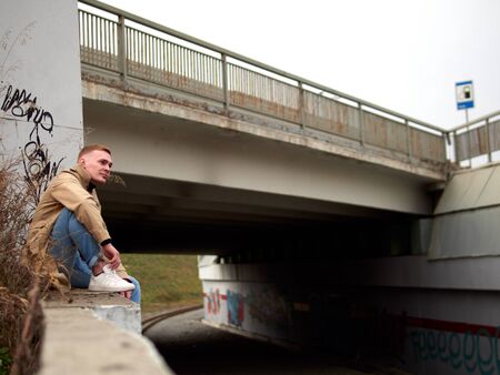 Autumn mood, young guy in a raincoat trench coat underground, street style.の写真素材