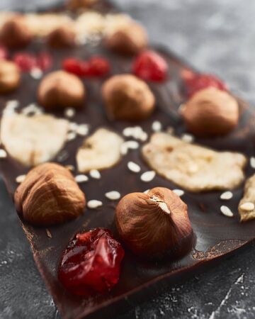 Handmade chocolate bar filled with cherries, bananas, sesame seeds and nuts.の写真素材