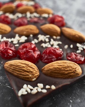 Handmade chocolate bar filled with almonds, cherries and sesame seeds.の写真素材