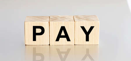 PAY - financial business concept on a white background. Wooden cubes.の写真素材