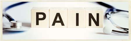 Medical stethoscope with wood block PAIN. Medicineの写真素材