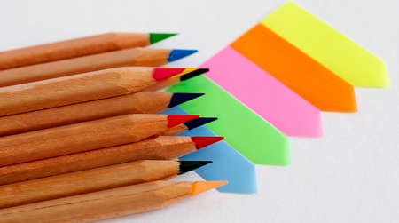 Colored pencils on a block of bright multicolored blank stickers