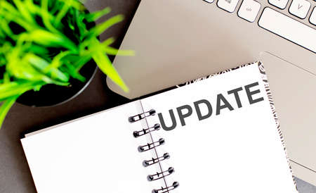 text writing Update. Concept meaning by adding new information or making corrections Up to date Notebook and writing equipment with computer.の写真素材