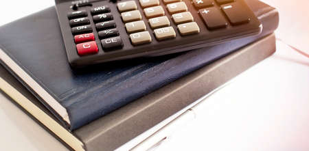 Calculator pen and notebook on white background