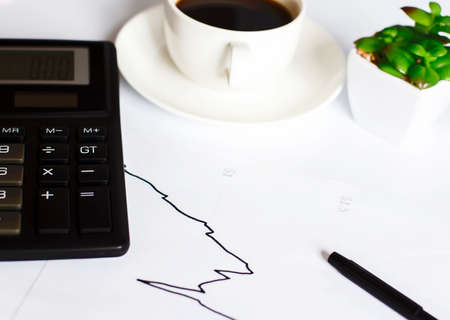 concept hand drawn on white blackboard with cup of coffee and calculatorの写真素材