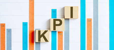 KPI word letters on wooden blocks on chart background. BUSINESS concept.の写真素材