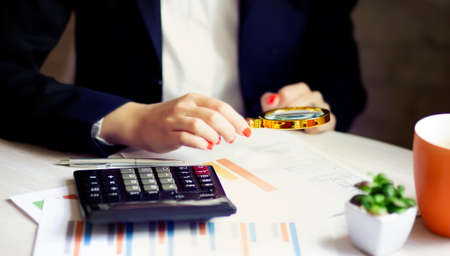 Business woman hand with Financial charts and calculator on table