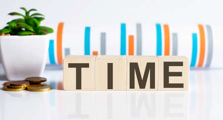 TIME word letters on wooden blocks with coins. BUSINESS concept.