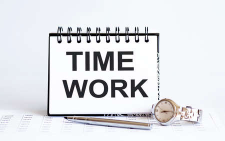 Word writing text TIME WORK on notepad. Business concept with clock, pen and chart on white backgroundの写真素材