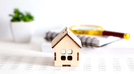 Housing market concept image with graph on chart background with notepad and magnifier