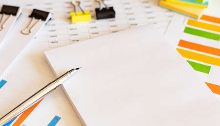 Documents with chart and graph and pen on white backgroundの写真素材