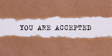 YOU ARE ACCEPTED written under torn paper on the white backgroundの写真素材