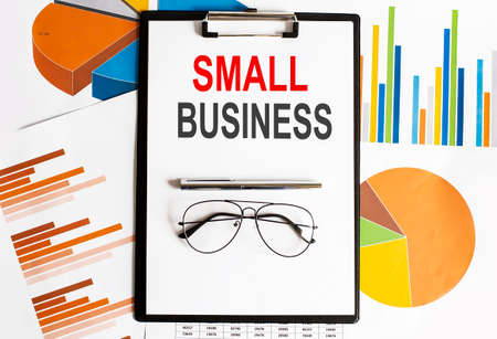 Small Business text. Conceptual background with chart, papers, pen and glasses
