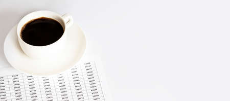 A white Cup of coffee next to the documents. A break with a Cup of coffee at work, business