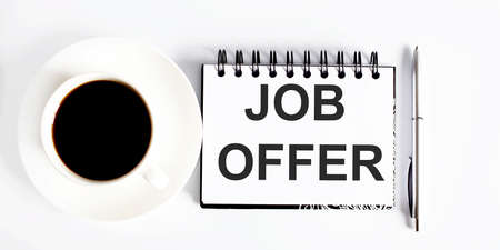 Text JOB OFFER, planning concept. notebook with text on the white background with coffeeの写真素材