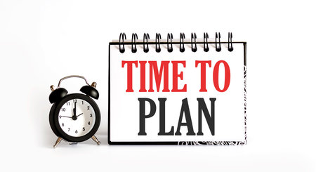 TIME TO PLAN notepad writing on the white background with alarm clockの写真素材