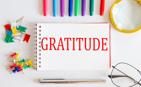 Notebook with Gratitude word with office tools on white table.の写真素材
