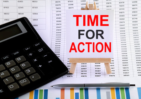 TIME FOR ACTION on small easel with charts, pen and calculator.Businessの写真素材