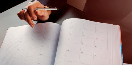 Women is writing notes and planning her schedule. Business