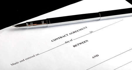 Close-up of silver pen on contract. Selective focus on the top of pen.