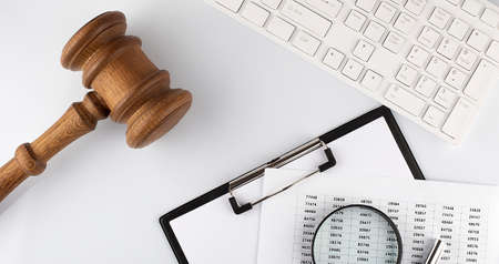 Work desk of contemporary lawyer. Lawyer office concept. Judge gavel near computer keyboard, respectable notebook on the white background top viewの写真素材