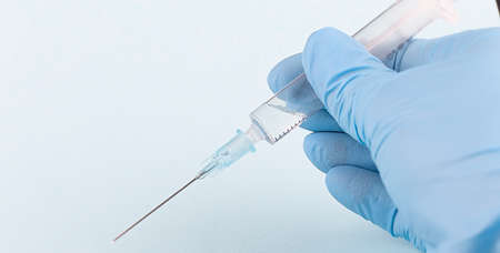 Hand holding syringe isolated on the white