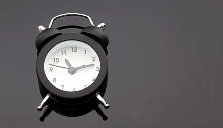 Alarm clock on the black background. Copy space