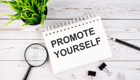Promote yourself text concept write on notebook with office tools on the wooden backgroundの写真素材