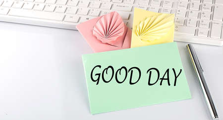 text GOOD DAY on colorful envelopes on keyboard on white backgroundの写真素材