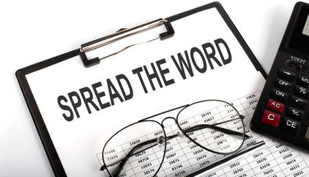 Clipboard with text Spread The Word with calculator, pen and chart. Businessの写真素材