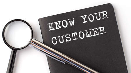 Know Your Customer - business concept, magnifier with white text message on the black notebook