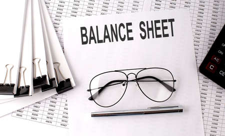 On the table are financial reports, a pen, calculator and a paper - BALANCE SHEET. Business, finance concept.の写真素材
