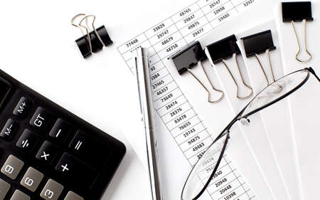 Charts and papers with calculator and glasses. Business