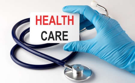 Card with text HEALTH CARE supplies, pills and stethoscope. Medicalの写真素材