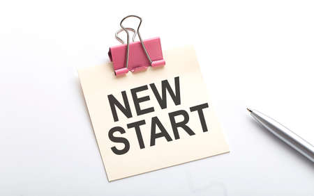 NEW START text on sticker with pen on the white background