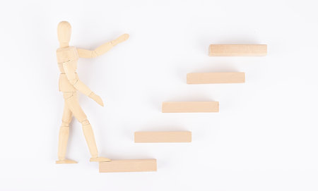 Wooden men walking up stairs, to career ledder, businessの写真素材