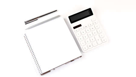 White notebook with a pencil, pen and calculator on a white backgroundの写真素材