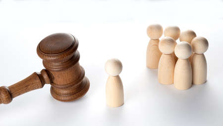 Court and law concept. Many wooden figures as people and judge gavel.