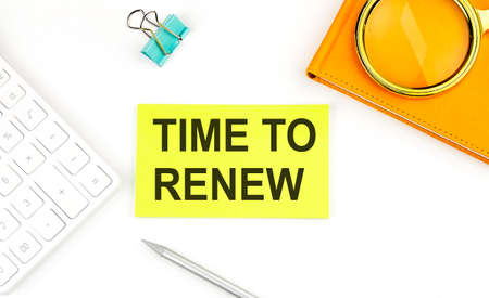 Sticker with the text Time to Renew on white background, near calculator and notebookの写真素材