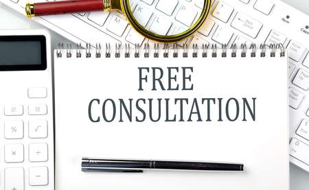 Free Consultation. Text on notepad with calculator and keyboard, business conceptの写真素材