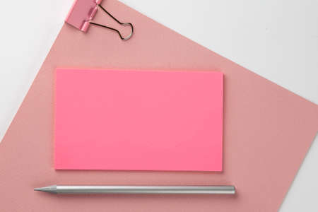 Pink sticker on pink paper with pencil on white backgroundの写真素材