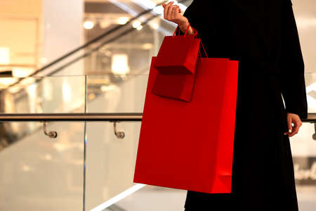 Black Friday, Woman holding red shopping bag on mall backgroundの写真素材