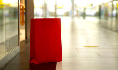 Red paper shopping bags standing on mall backgroundの写真素材