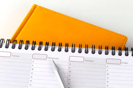 Planner on week and yellow notebook, business