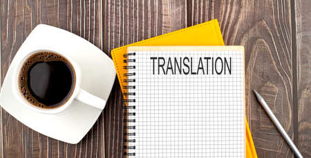 TRANSLATION text on notebook with coffee on wooden backgroundの写真素材