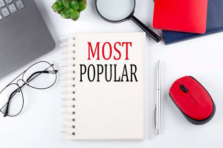 MOST POPULAR. text on a notepad with laptop on white background